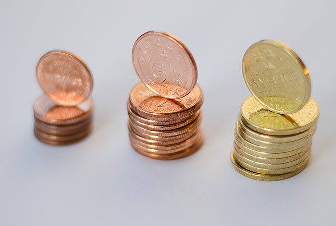 Tre staplar med mynt i olika valörer.