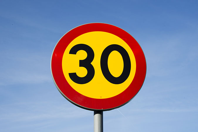 En vägskylt för hastighetsbegränsning 30-väg.